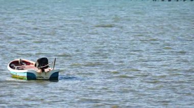 Small boat gently drifts on calm sea