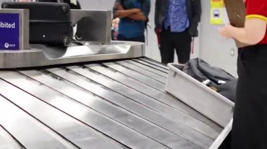 Suitcases moving on a conveyor at Bangkok airport