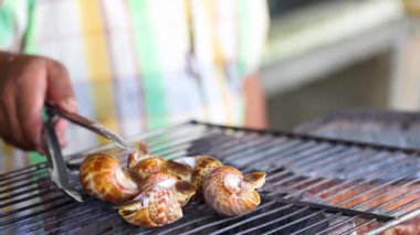 Izgarada ızgara yapan deniz salyangozları.