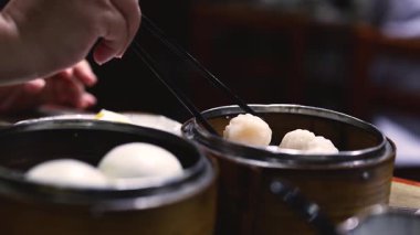 Yemek çubukları buhardan karides köftesi topluyor.