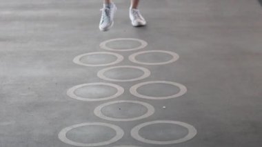 Desenli bir zeminde seksek oynayan kişi