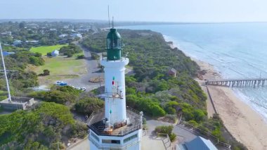 İHA görüntüleri ikonik Point Lonsdale Deniz fenerini, yemyeşil alanları ve parlak gün ışığında geniş kıyı şeridini yakalar.
