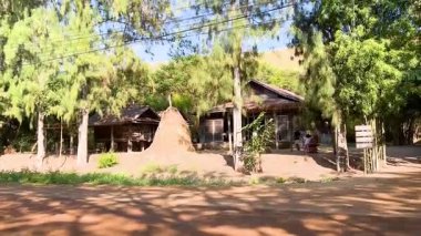 Beyaz bir minibüs kırsal bir yerden geçiyor.