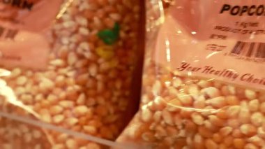 Süpermarket rafındaki patlamış mısır ve dal torbalarının yakın çekim videosu, paketleme ayrıntıları ve ürün düzenlemesi