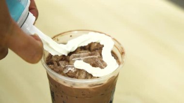 Çikolatalı içeceğe krema ekliyorum.