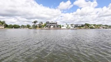 Nehir kenarındaki evler Parlak, bulutlu bir gökyüzünün altında