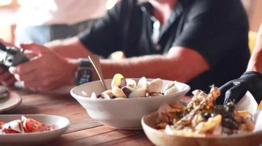 Yemek masasında yemek servisi yapan eller.