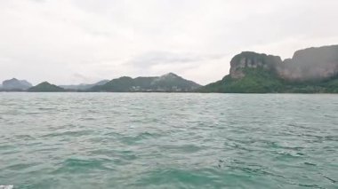 Uzak dağlarla okyanus ve ada manzarası