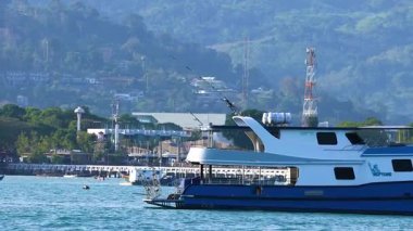 Tayland, Phuket yakınlarındaki bir balıkçı teknesi sürekli okyanusu aşıyor. Sahne, berrak gökyüzünü ve sakin suları yakalıyor.