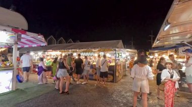 İnsanlar hareketli gece pazarlarını keşfediyorlar.