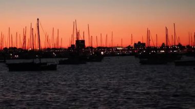 Canlı bir günbatımına karşı gölgeli tekneler