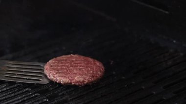 Hamburger köftesi alevlerle kızartılıyor.