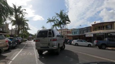 Arabalar ve palmiye ağaçları sessiz bir caddede.