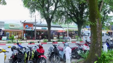 Tayland 'da kalabalık bir cadde boyunca park etmiş Moped' ler.
