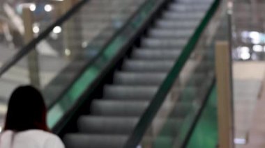 Binada yürüyen merdivene binen biri.