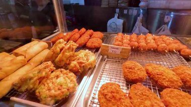 Melbourne 'da canlı bir sokak yemeği sergileniyor. Sıcak ışık altında yumurtalı börek, tavuk ve deniz tarağı sergileniyor.