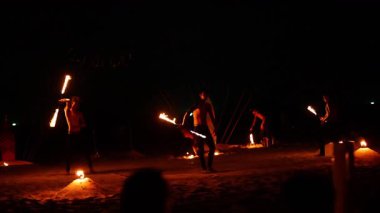 Karon Sahili, Phuket 'te dinamik yangın performansı, gece gökyüzü altında ateşli sahne donanımları olan yetenekli sanatçılar.