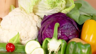 Canlı bir taze sebze çeşidi sanatsal olarak düzenlenmiş, organik ürünleri parlak, doğal ışıklandırmada sergiliyor.