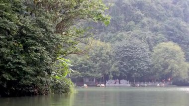 Tapınağın yakınındaki sakin bir nehirde tekneler.