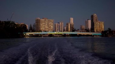 Tekne şehrin ufuk çizgisiyle suda hareket ediyor.