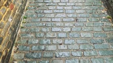 Dar bir kaldırım taşının üzerinde ayak izleri.