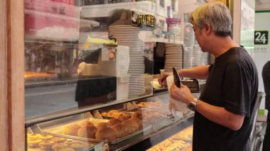 Adam pastanede hamur işi seçiyor.