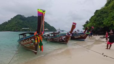 İnsanlar kumlu bir plaja tekne çekiyor.