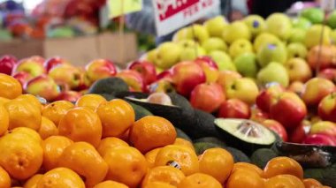 Meyve pazarında portakal seçen kişi