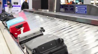 Bavullar bagaj teslim atlıkarıncasında taşınıyor.