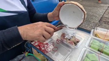 Sokak satıcısı geleneksel Tayland tatlısını hazırlıyor.