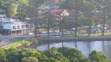 İnsansız hava aracı Brunswick Heads, NSW 'de sakin bir nehir ve kasaba manzarası yakalıyor, yumuşak gün ışığında, tekneleri, yeşillikleri ve kentsel yaşamı vurguluyor.