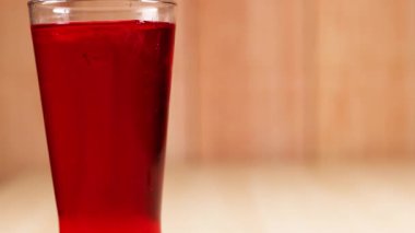 Kırmızı meşrubatla dolu bir bardak.