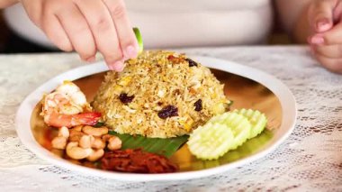 Bir insan pirinç tabağına limon ekler.