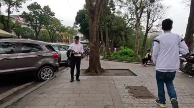 İnsanlar yürüyor, oturuyor ve parkın tadını çıkarıyor.