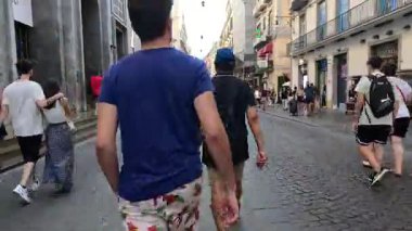 İnsanların yürüdüğü ve alışveriş yaptığı kalabalık bir cadde.