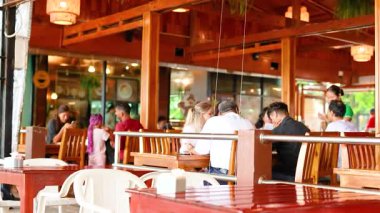 İnsanlar enerjik bir restoranda yemeğin tadını çıkarıyorlar.