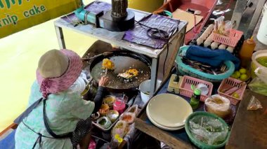 Tedarikçi yüzen pazarda Pad Thai hazırlıyor.