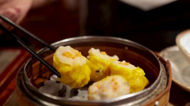 Çubuklar bambu budan siu mai topluyor.