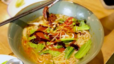 Bangkok 'taki bir restoranda sıcak ışıkta yakalanan canlı bir Vietnam piposu et ve taze otlarla dolu.