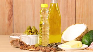 Tahta bir yüzeyde doğal ışıklandırmayla sıralanmış çeşitli sağlıklı yağ ve yağlar.