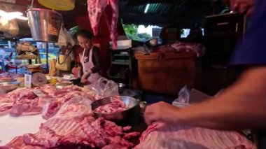 Kasap kalabalık bir markette pirzola kesiyor.