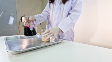 Bilim adamı deney tüpleri ve renkli sıvılarla canlı bir kimyasal deney yürütüyor.