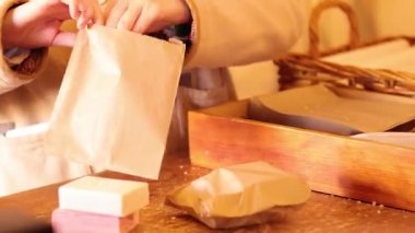 Eller, sabun kalıplarını kahverengi kağıda sarıyordu.