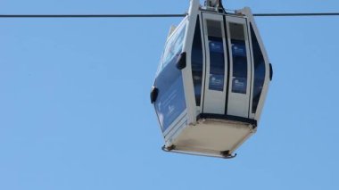 Açık mavi gökyüzünde hareket eden kablo araba