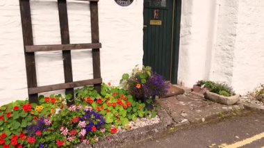 Canlı çiçek bahçeli bir kulübe girişi.