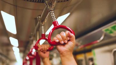 Hareket eden bir trende elleri kavrayan eller.