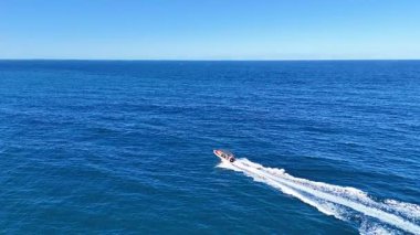 Bir sürat teknesi açık okyanus sularında hızla yol alır.