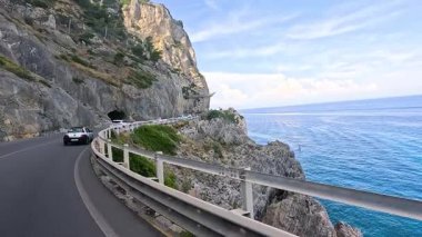 Uçurum kenarındaki sahil yolunda giden arabalar