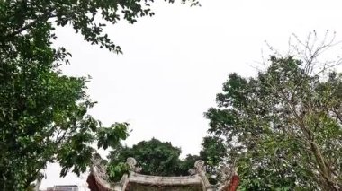 Bayraklı ve yemyeşil bir tapınak girişi.