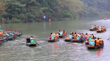 Turist grupları güzel bir gölde kürek çekiyorlar.